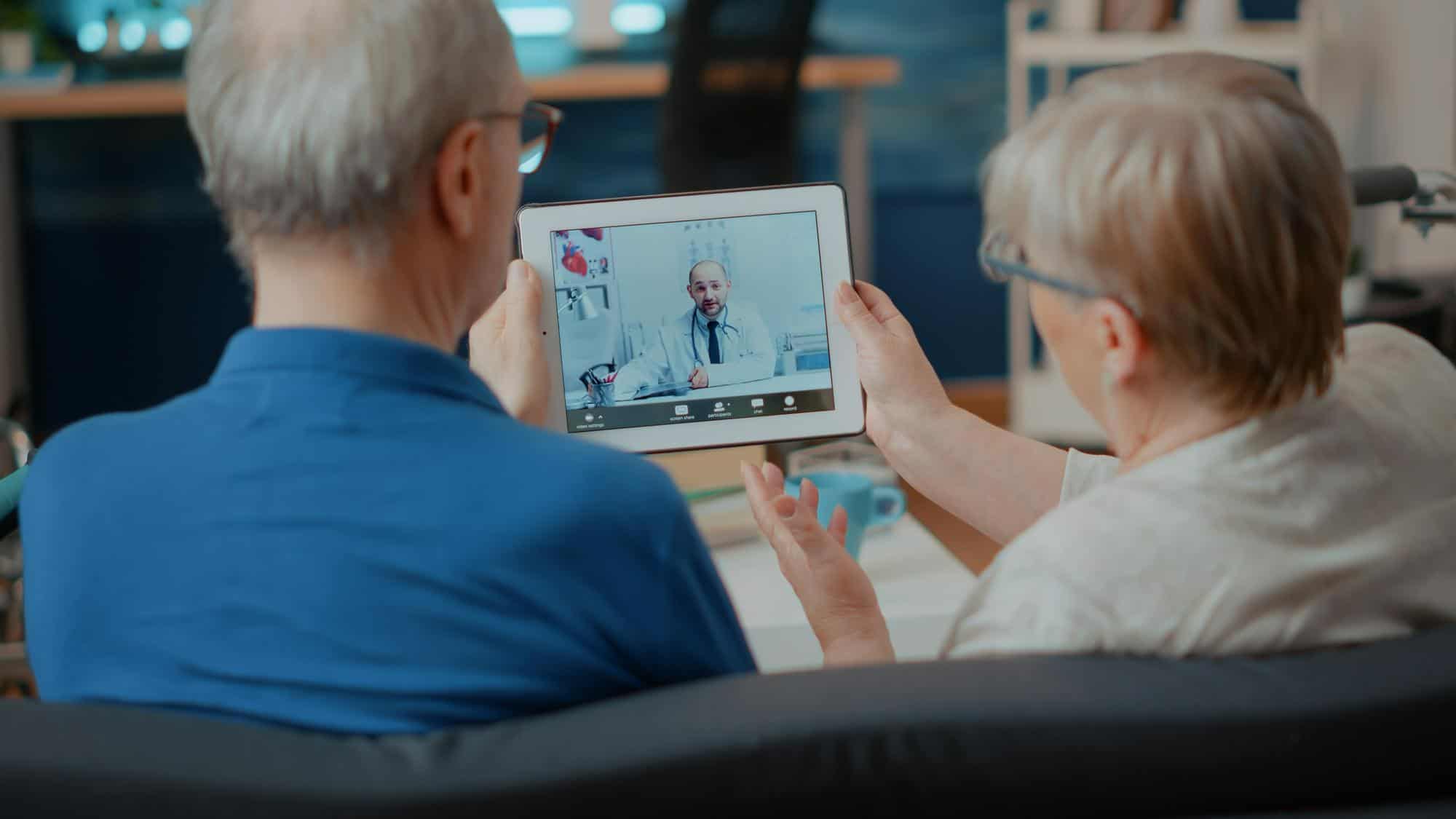 senior couple attending online meeting with doctor digital tablet doing remote consultation home elder people using videoconference call modern gadget internet telemedicine